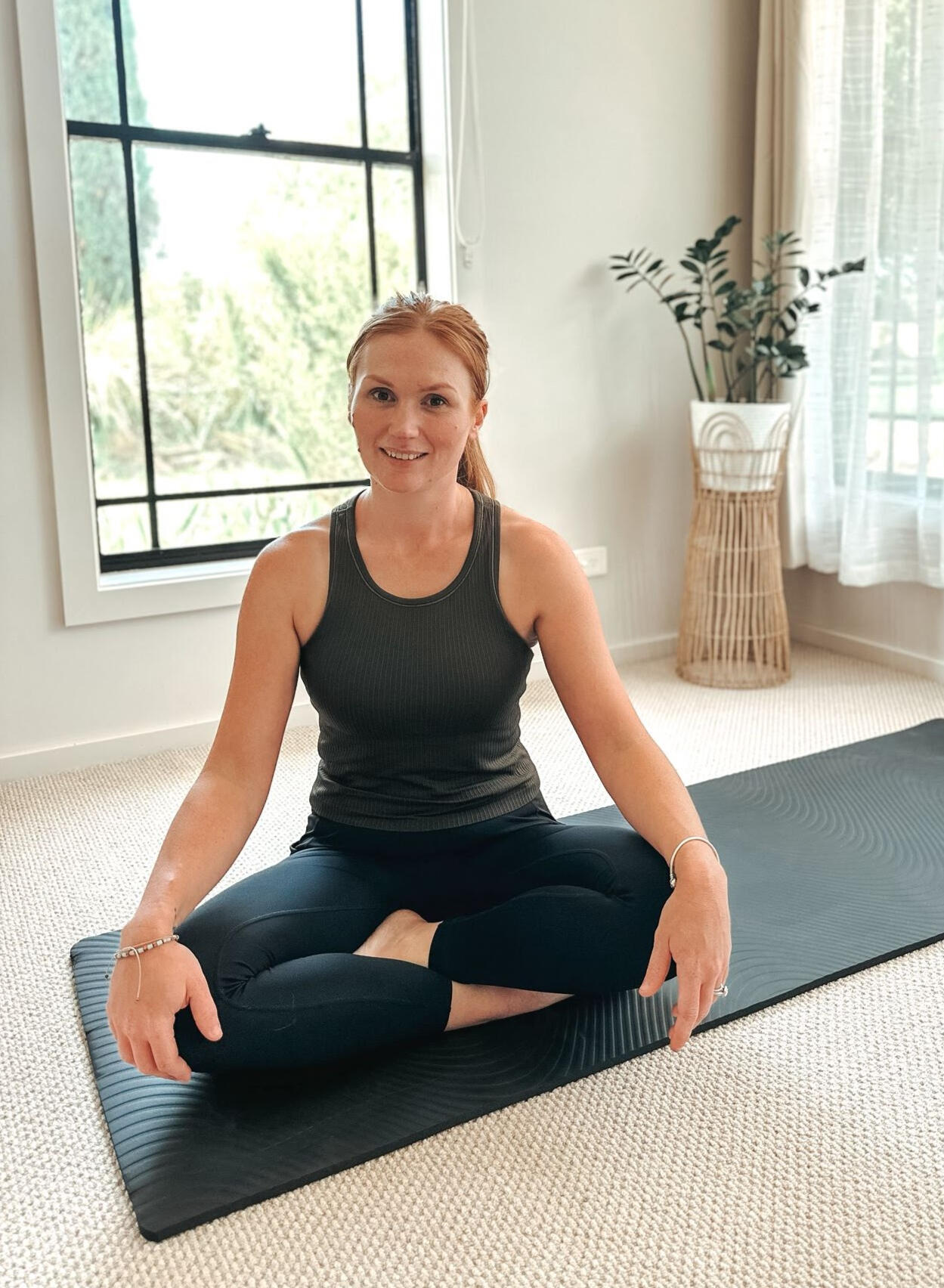 Abbie, mat Pilates instructor in the Southern Highlands, seated on a Pilates mat